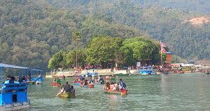 डुङ्गा चढेर फेवातालकाे मध्यभागमा रहेकाे तालबराही दर्शन गर्न जाँदै गरेका भक्तजन